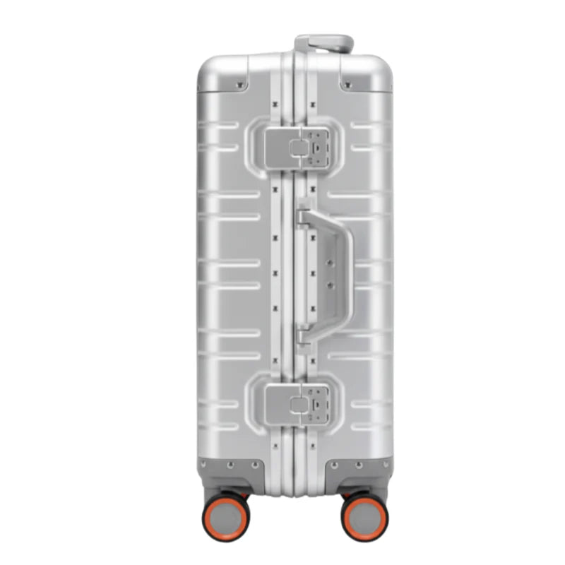 Vue de côté d'une valise en aluminium argenté avec un cadenas et des roulettes rouges.