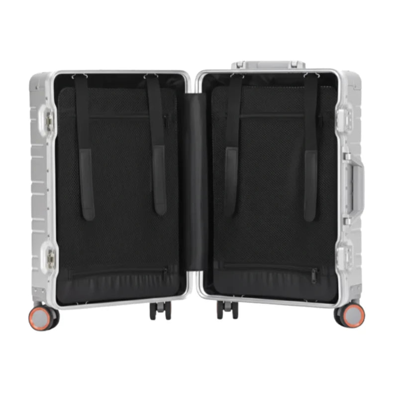 Intérieur d'une valise en aluminium argenté avec des sangles de maintien et des compartiments en tissu noir.