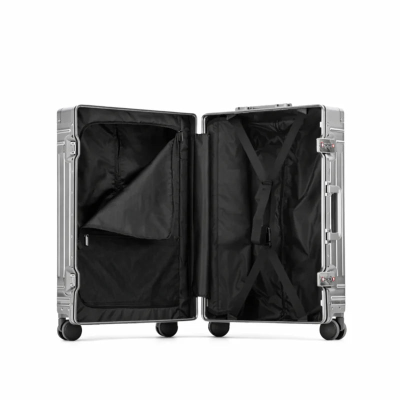 Intérieur de valise rigide en aluminium argenté, avec compartiment principal et poche zippée, vue du côté ouvert.